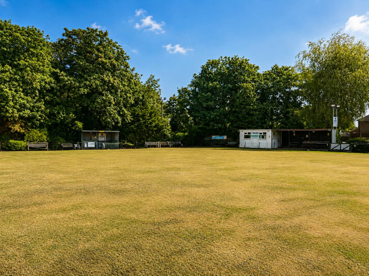 Crown green bowling green at Alford Hall with benches and clubhouse buildings